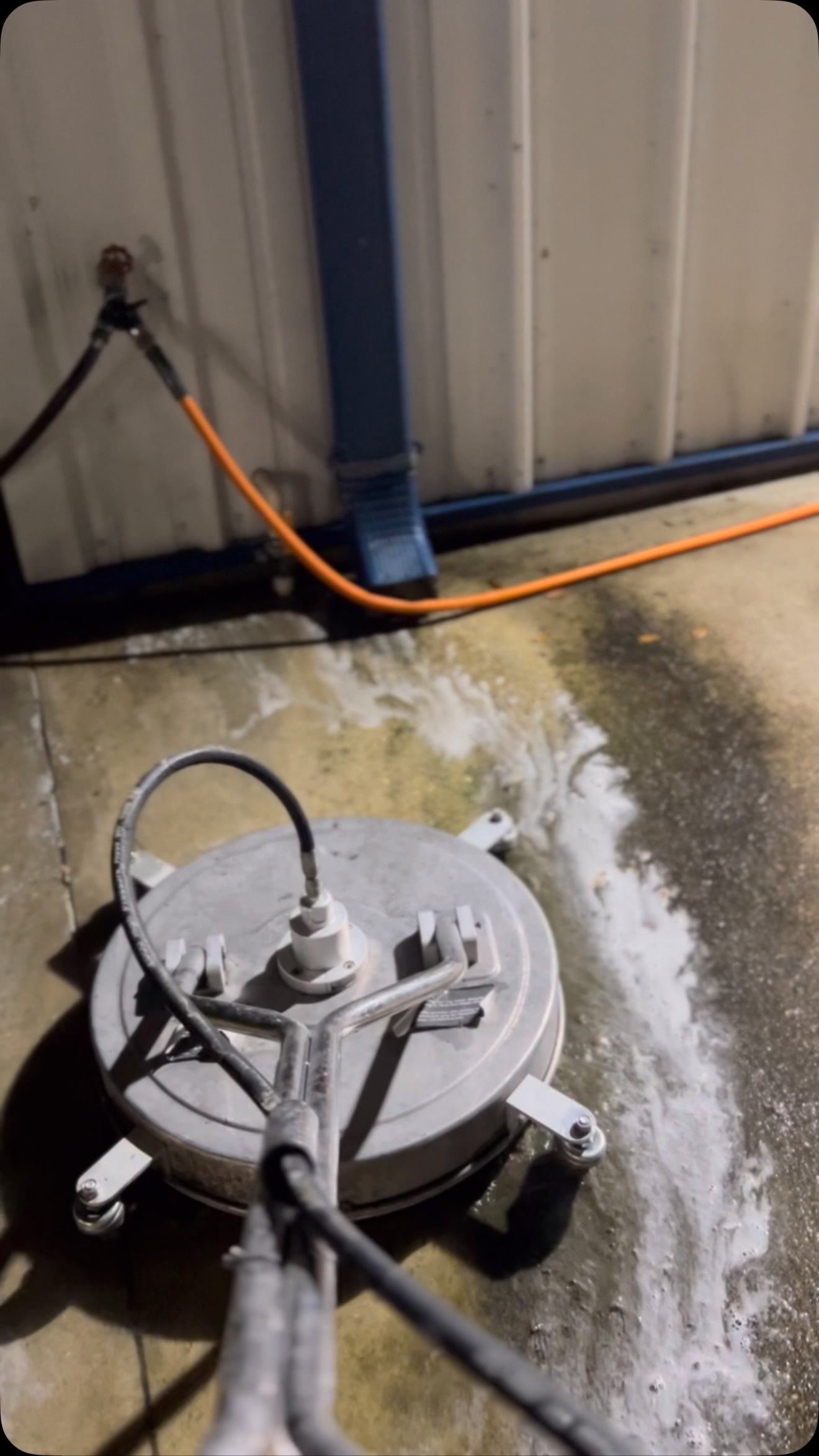 High-flow concrete and driveway surface cleaning in progress.